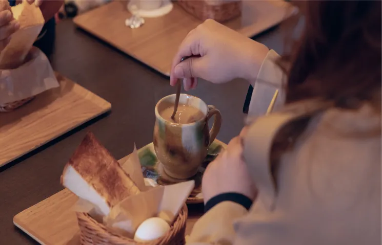 朝食のシーンで、陶器の器を使ってコーヒーを飲む様子。